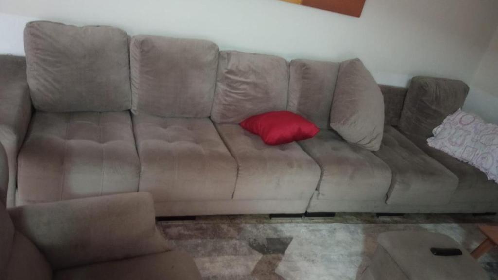 eine braune Couch mit einem roten Kissen drauf in der Unterkunft Propriedade teste 1 in Cachoeira Paulista