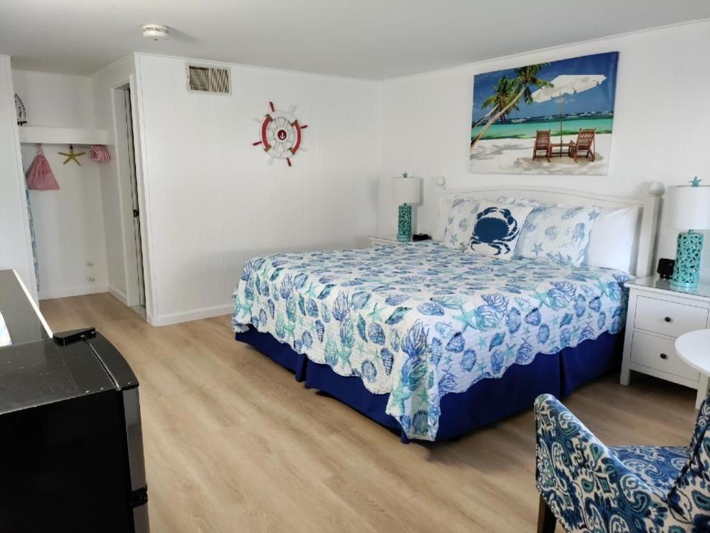 1 dormitorio con 1 cama con colcha azul y blanca en Mariner Motel, en Falmouth