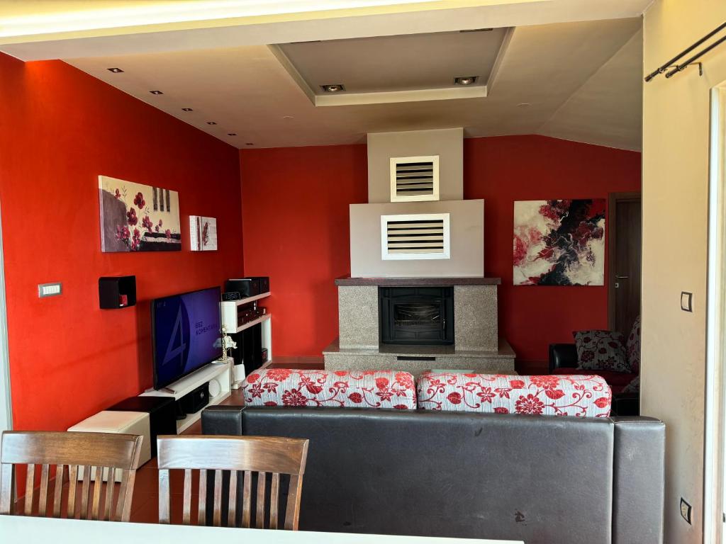 a living room with red walls and a fireplace at Apartment Pupina in Žrnovnica