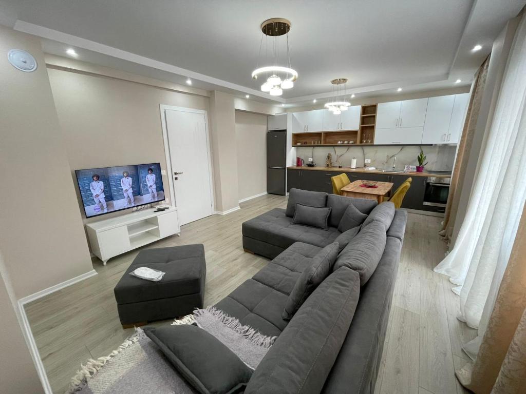 a large living room with a couch and a tv at Melody Apartment in Korçë in Korçë