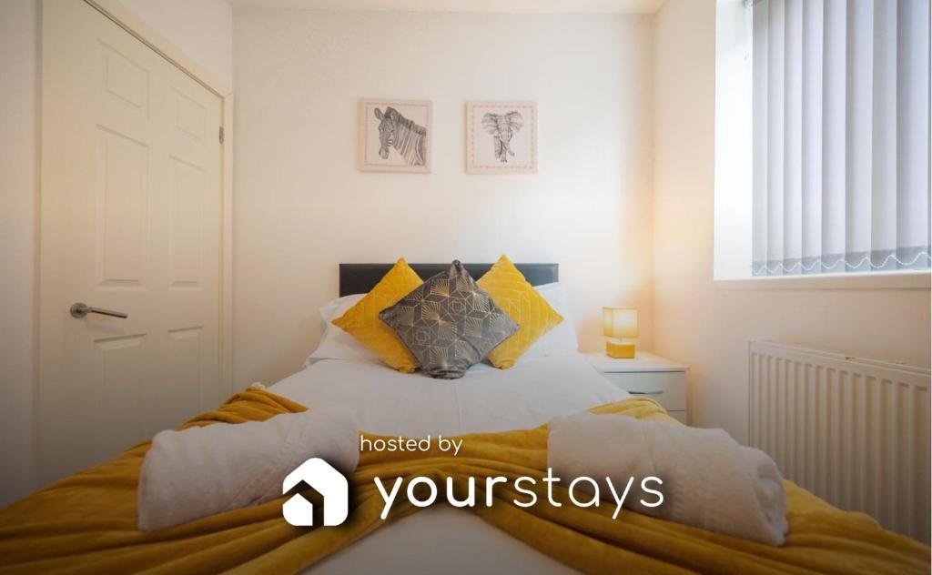 a bedroom with a bed with yellow pillows at Pottery House by YourStays in Stoke on Trent
