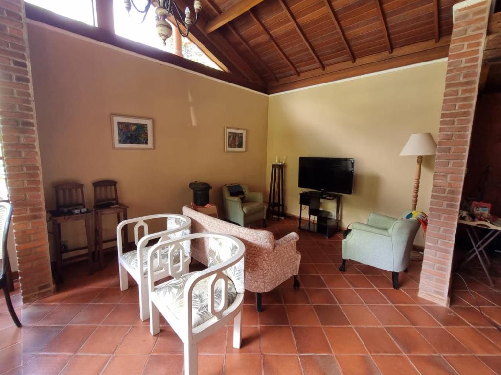 米格爾佩雷拉的住宿－Sítio Canto a Canto，客厅配有白色椅子和电视