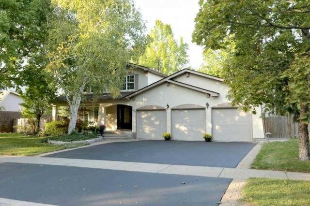 une maison blanche avec un garage et une allée dans l'établissement Quiet and Comfortable Homestay, à Oakville
