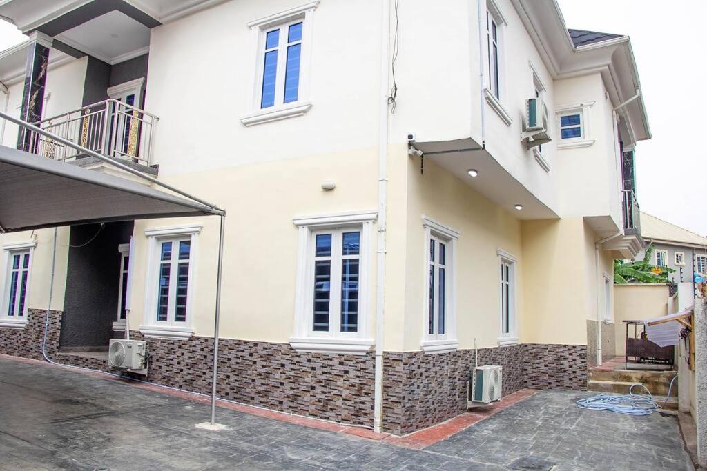 a large white building with windows on a street at Cozy Urban Oasis 3 Bedroom in Ogba, Ikeja, Lagos in Ogba