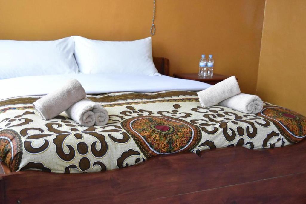 a bedroom with a bed with towels on it at Room in BB - Amahoro Guest House - Queen Room in Ruhengeri