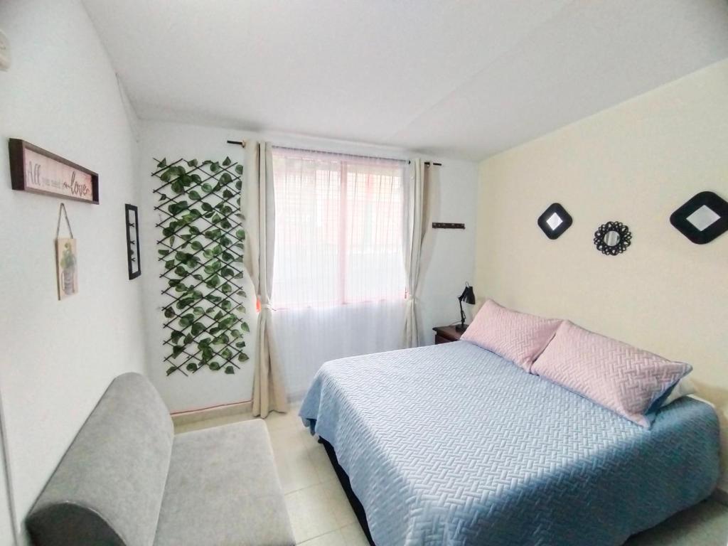 um quarto com uma cama e uma janela em Apartamento Familiar Privado 101 Con Baño Cocina Tv Wifi Sala em Salento