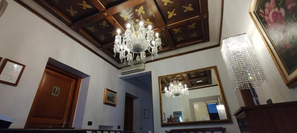 uma sala de jantar com um lustre pendurado no tecto em Soggiorno Michelangelo em Florença