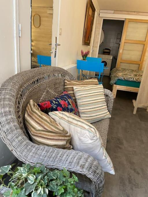 a wicker couch with pillows in a living room at Studio in Condom