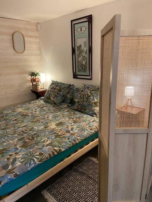 a small bedroom with a bed and a mirror at Studio in Condom