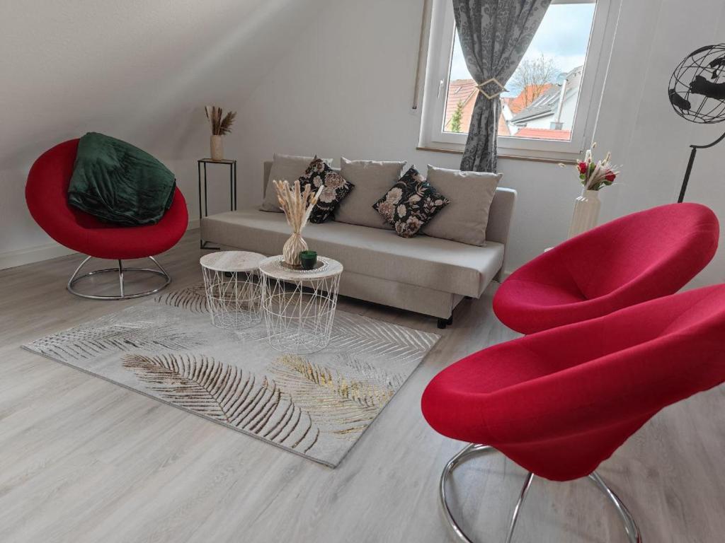 uma sala de estar com cadeiras vermelhas e um sofá em Home sweet home in Ludwigsburg em Ludwigsburg
