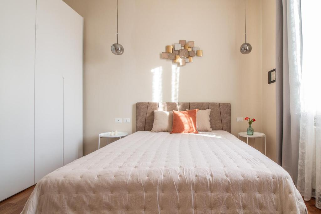 um quarto com uma grande cama branca com almofadas laranja em Ginevra Home Bologna -Self check-in em Bolonha