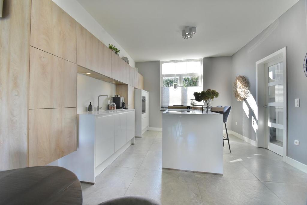 une cuisine avec des placards blancs et un comptoir dans l'établissement Stylish Home near Maastricht Alicias house, à Lanaken