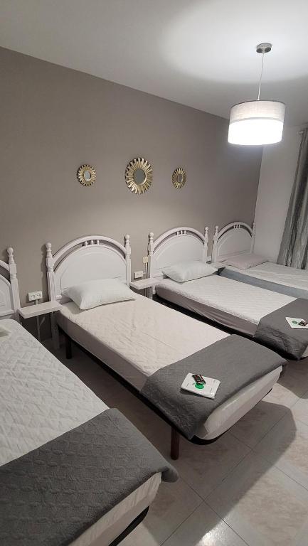 1 dormitorio con 2 camas y espejo en la pared en ALBERGUE de Caldas de Reis URRACA en Caldas de Reis