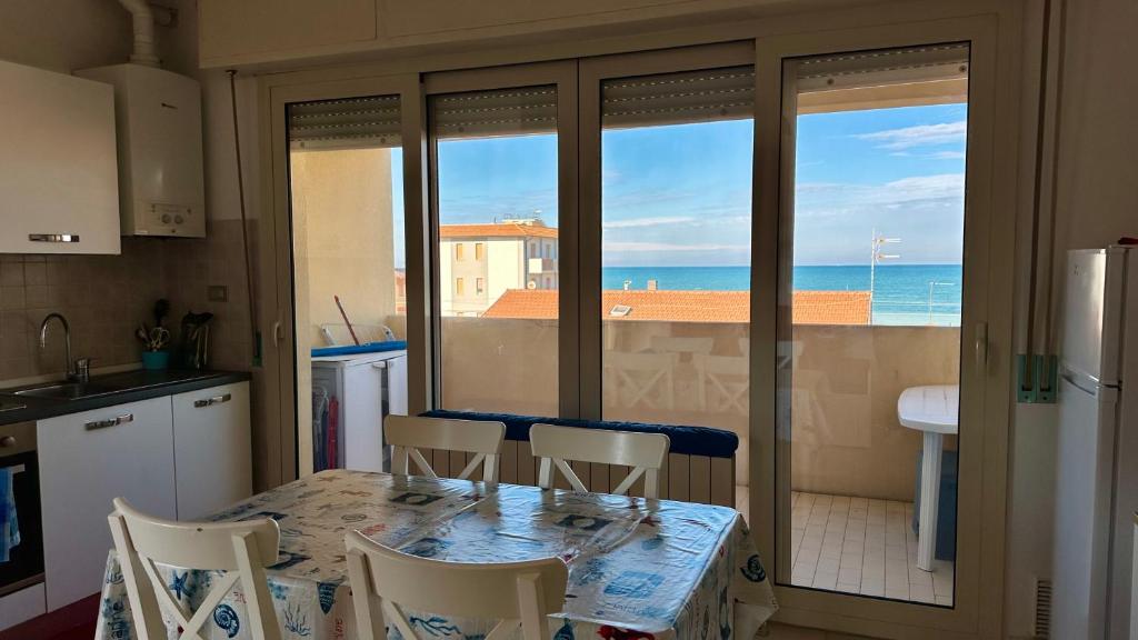 a kitchen with a table and a view of the ocean at SE063 - Marzocca, delizioso bilocale comodo al mare in Marzocca di Senigallia