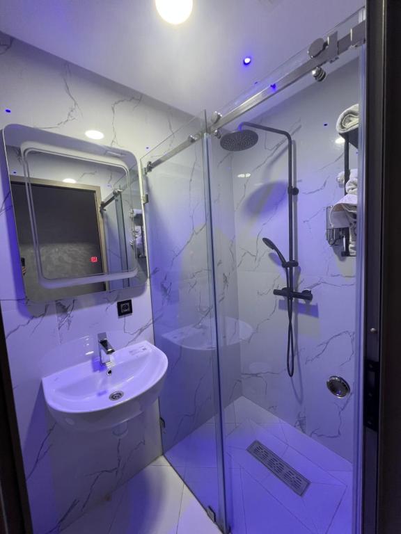 bagno bianco con lavandino e doccia di Appartement Wow ad Al-Ḥoseyma