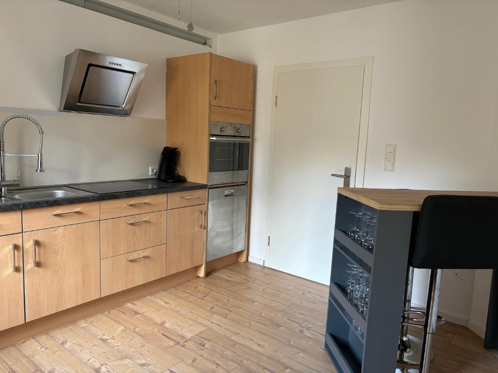 uma cozinha com armários de madeira, um lavatório e um micro-ondas em Ferienwohnung Reinhardt em Oestrich-Winkel