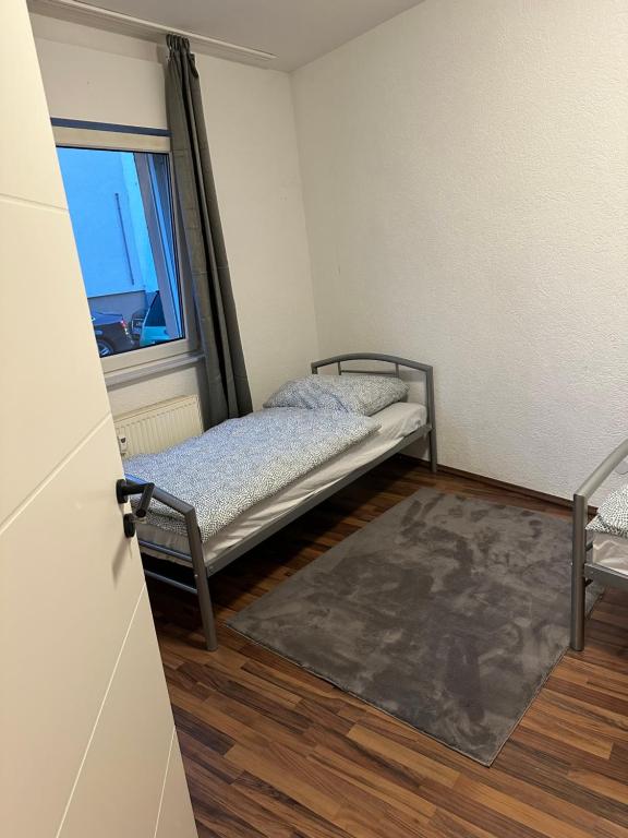 ブルッフザールにある2 Zimmer mit 4 Betten (Wohnung Apartment)のベッドと窓が備わる小さな客室です。
