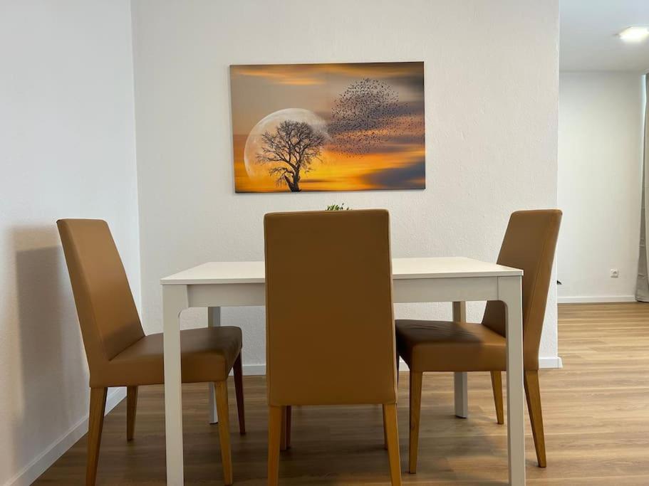 een eettafel met stoelen en een schilderij aan de muur bij Sonnenschein-Oase ,Apartment in Marl