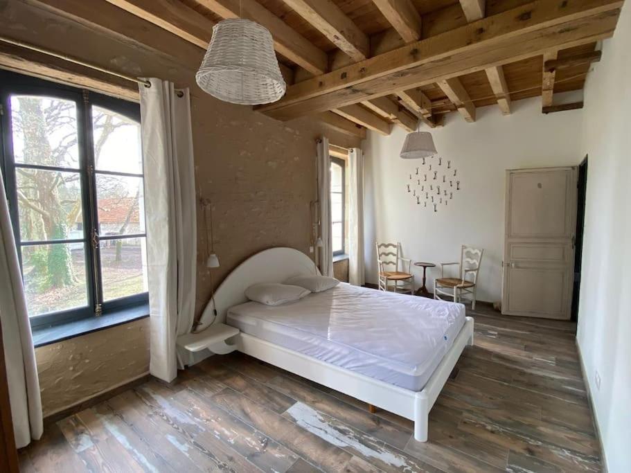- une chambre avec un lit, une table et des chaises dans l'établissement Authentique moulin à eau du ⅫⅠe siècle, à La Vernelle