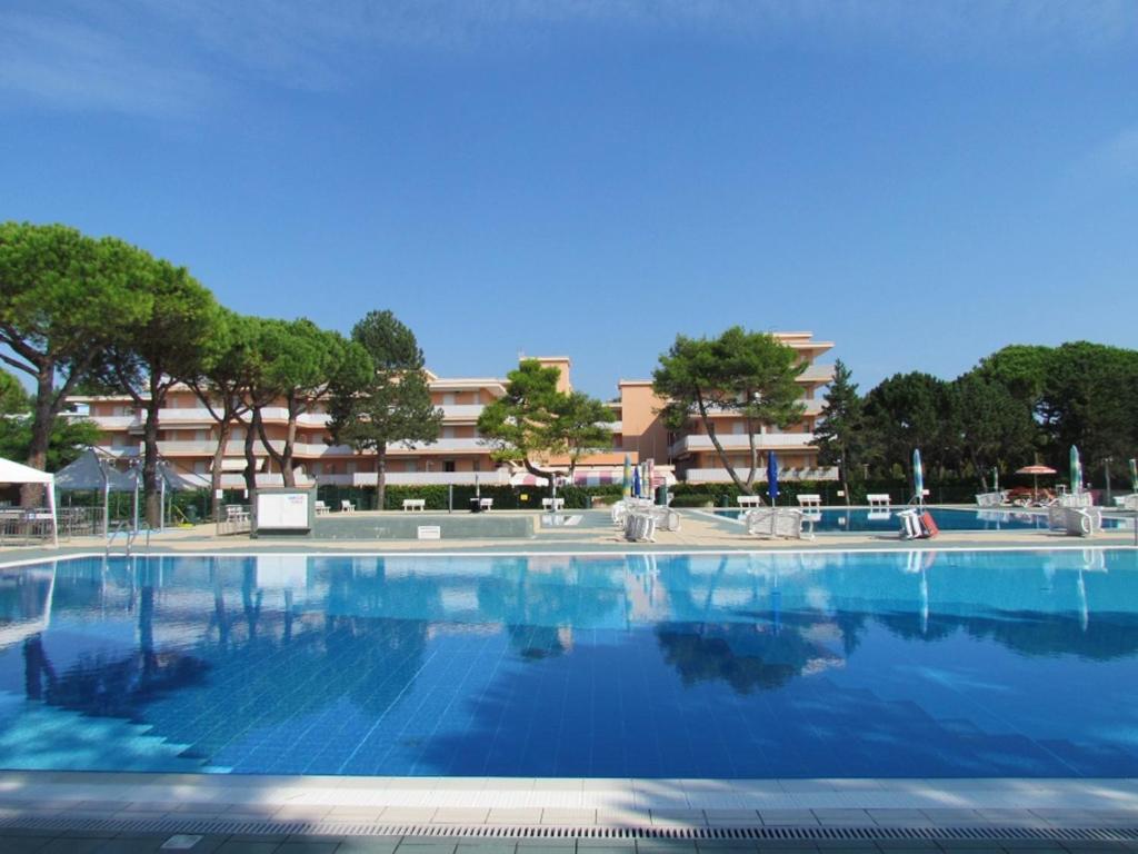 a large swimming pool with a building in the background at Super nice studio in amazing residence in Bibione