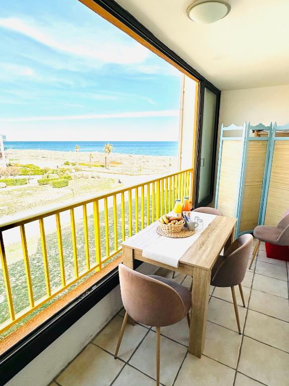 Un comedor con mesa y vista a la playa. en Escale au Sud, un appart les pieds dans l eau :), en Le Barcarès