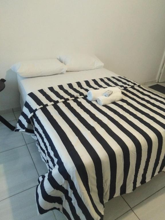 een bed met een zwart-wit gestreepte deken bij 17 on Driffield in East London