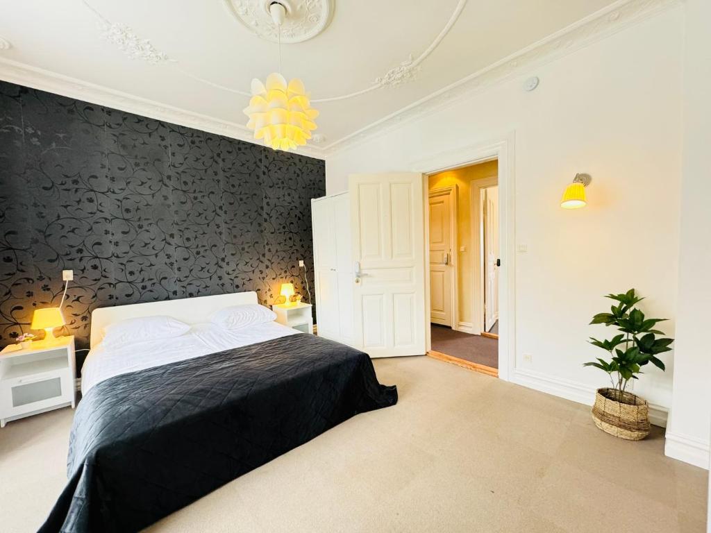 een slaapkamer met een bed en een muur met zwarte accenten bij aday - Villa Firenze - 2 Bedrooms Bright Apartment in Aalborg