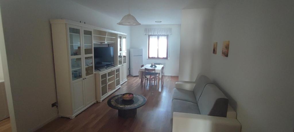 ein Wohnzimmer mit einem Sofa und einem Tisch in der Unterkunft Il Rifugio in Tarvis