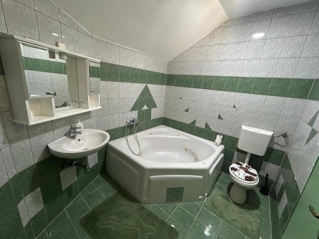 a bathroom with a tub and a sink and a toilet at Rooms ALEA in Sanski most