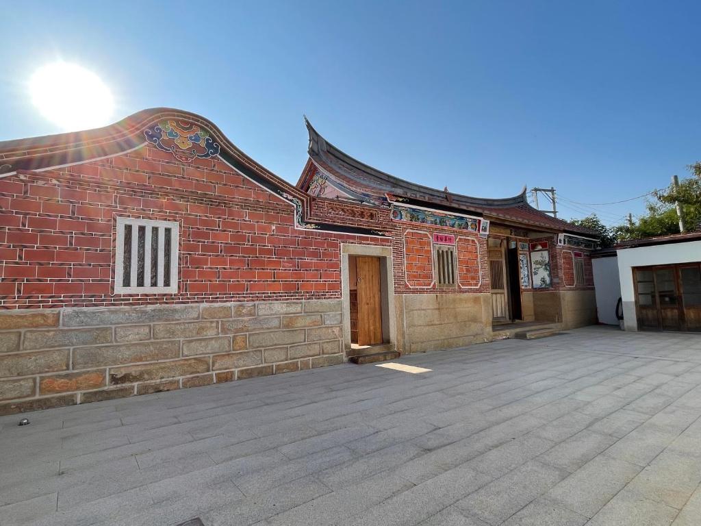 budynek z czerwonej cegły z drzwiami w obiekcie Sunshine Music Traditional Guesthouse w mieście Jinsha