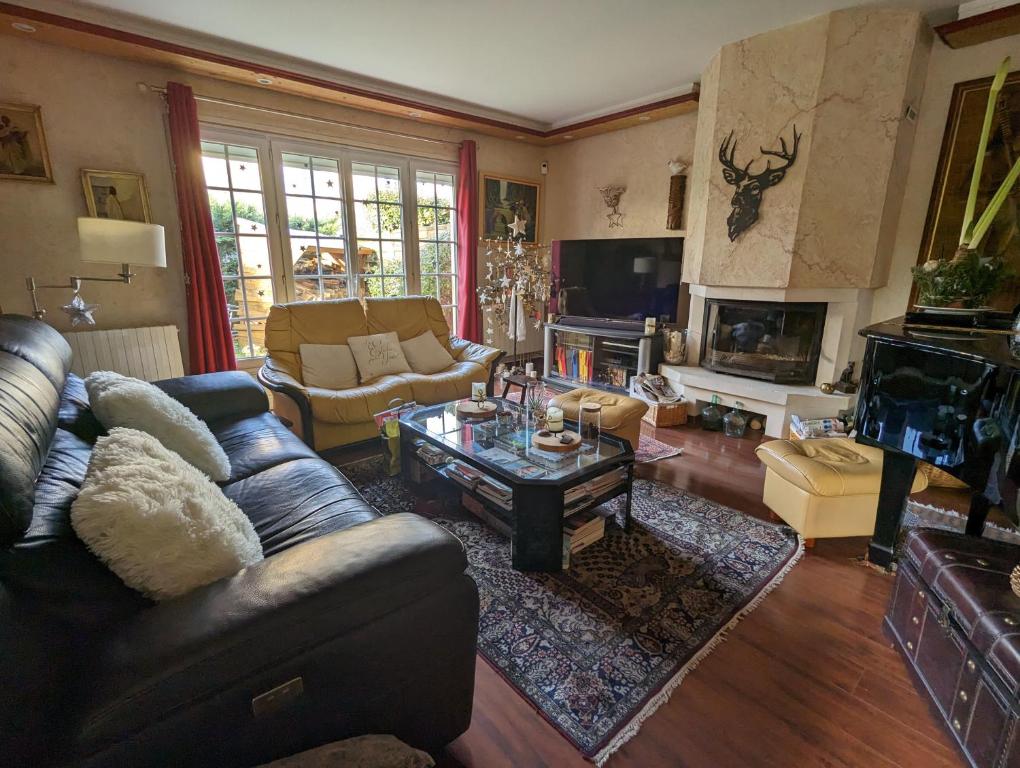uma sala de estar com um sofá e uma mesa de centro em Chambre dans une maison pendant les Jeux Olympiques em Rambouillet