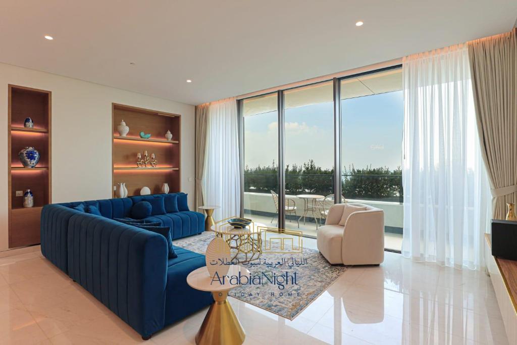 a living room with a blue couch and a large window at Arabian Nights - Oceanfront Luxurious Living at Atlantis The Royal in Dubai