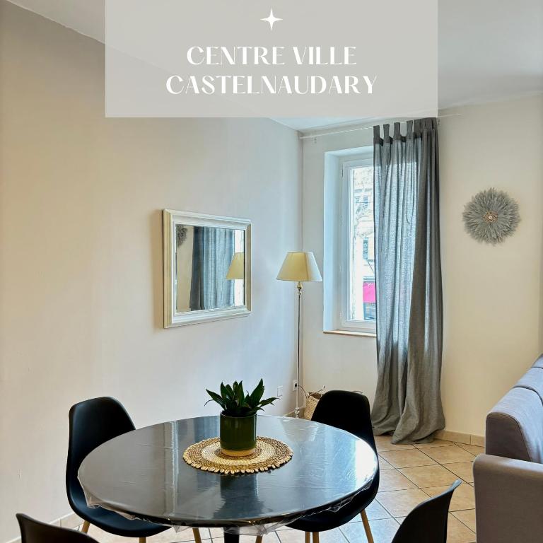 ein Wohnzimmer mit einem Tisch und Stühlen in der Unterkunft Appartement central à Castelnaudary in Castelnaudary