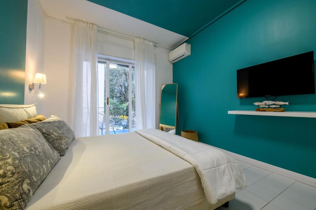 - une chambre bleue avec un lit et une télévision dans l'établissement Testa's house Sorrento, à Sorrente