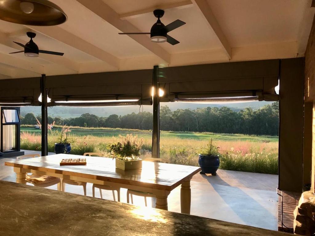 a patio with a table and a view of a field at Highland Gate Belhaven in Dullstroom