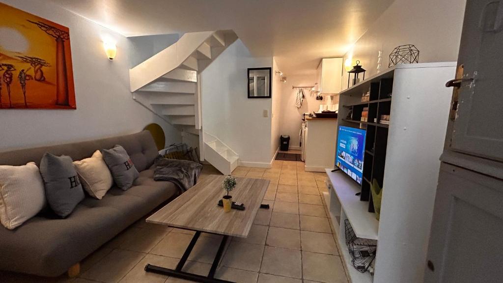 un salon avec un canapé et une télévision dans l'établissement Duplex Paris 12èmè Près De Nation, à Paris