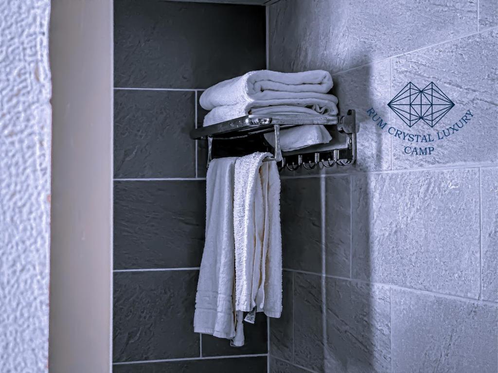un grupo de toallas colgadas en la pared del baño en Rum Crystal Luxury Camp, en Wadi Rum