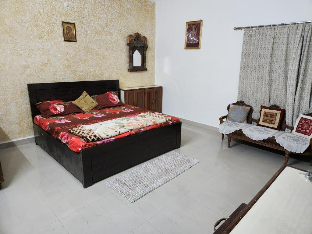 a bedroom with a bed with a red comforter at Shri Achyutam Villa in Vrindāvan