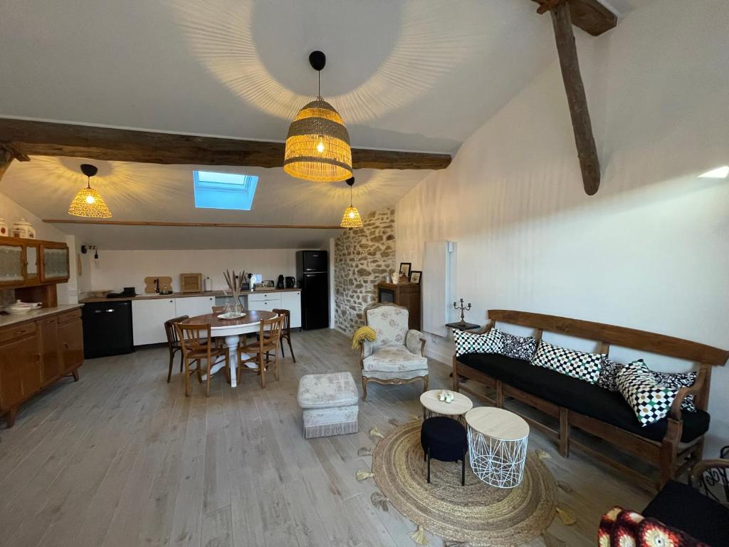un salon avec une table et une cuisine dans l'établissement Maison de village Cœur Andéol, à Saint-Andéol-le-Château
