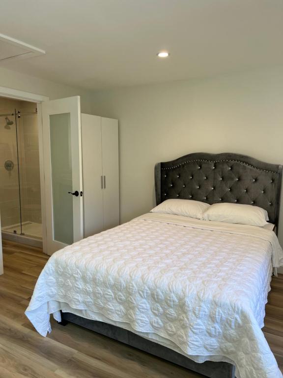 a bedroom with a large bed and a walk in shower at One room with one queen bed studio to rent in Palo Alto