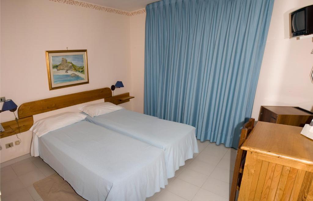 Hotel Marinella tesisinde bir odada yatak veya yataklar