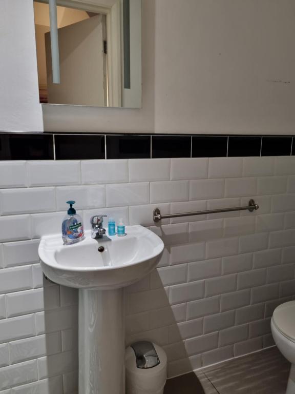 a white bathroom with a sink and a toilet at The Windmill Hotel in London