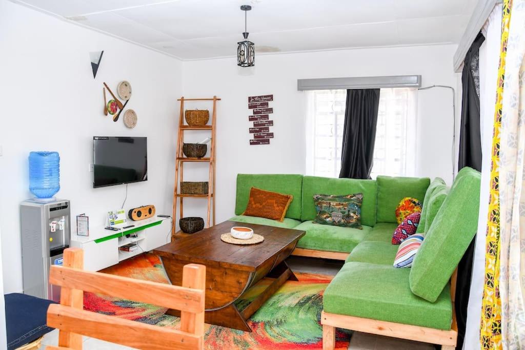 a living room with a green couch and a table at Familia@HeArt in Kakamega