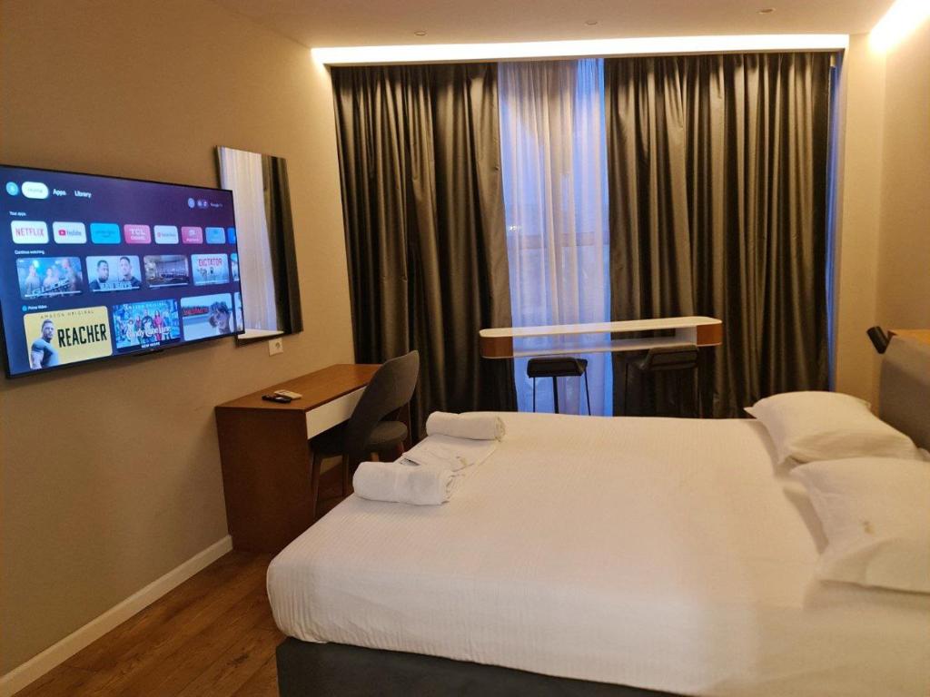 Star Hotel Astir في تيرانا: غرفة فندقية بسريرين وتلفزيون بشاشة مسطحة