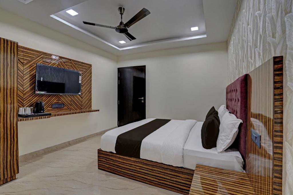 1 dormitorio con 1 cama y TV de pantalla plana en OYO 82334 Hotel Keshri Inn en Prayagraj