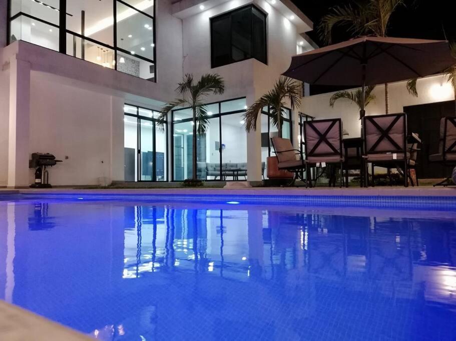 a house with a swimming pool at night at Bella Casa Blanca in El Castillo