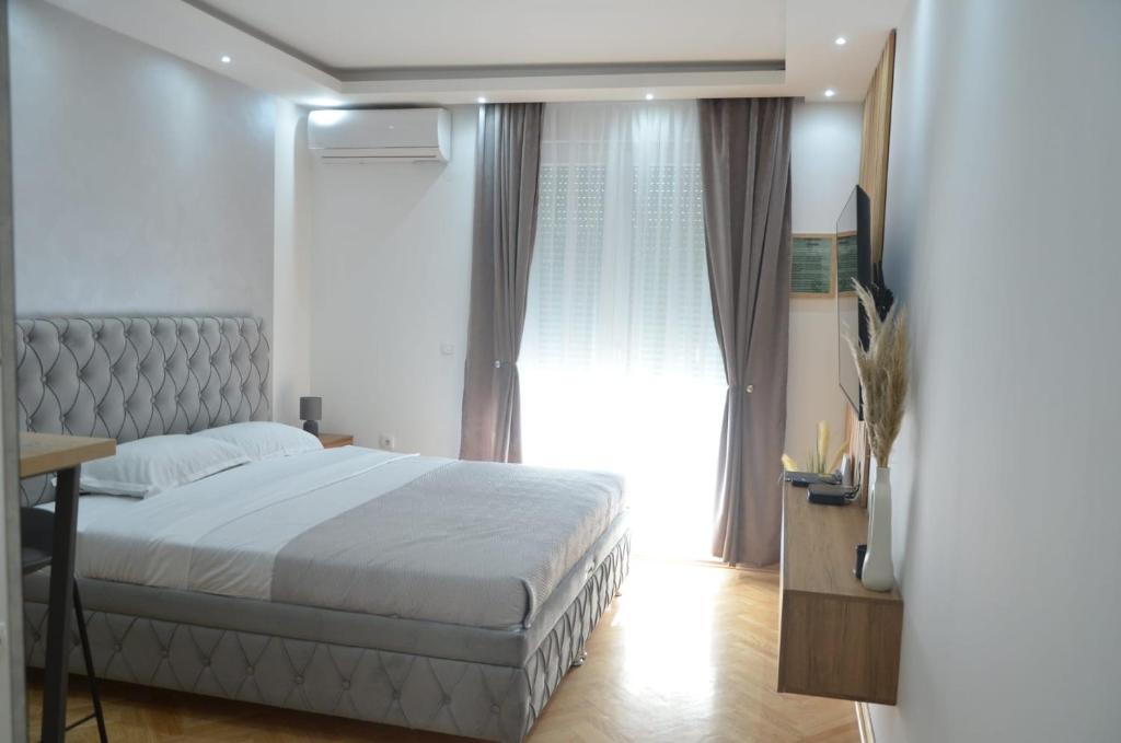 een slaapkamer met een bed en een groot raam bij Apartman La Luna, Vrnjacka Banja in Vrnjačka Banja