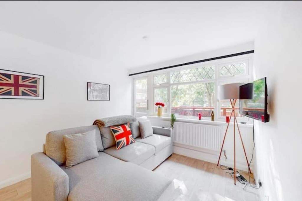 - un salon avec un canapé et une fenêtre dans l'établissement Newly renovated 4BR in Kings Cross with Garden, à Londres