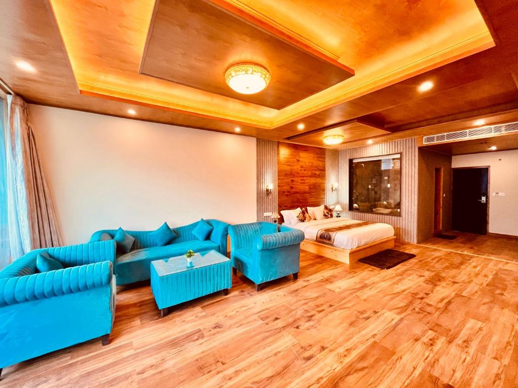 a living room with blue furniture and a couch at Rockland Cottage, Manali - Centrally Heated & Air Cooled Premium Rooms in Manāli