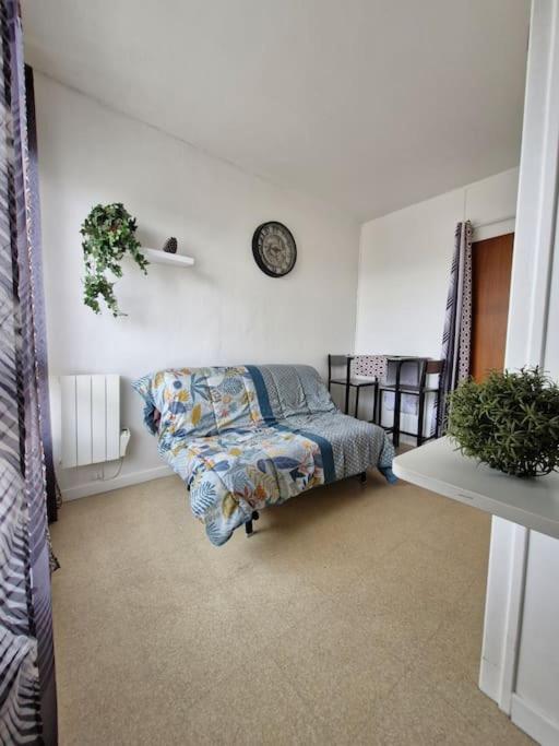 une chambre avec un lit et une horloge au mur dans l'établissement Studio - Marina 5 - 31 allée des Pignons - 4-1, à Saint-Jean-de-Monts